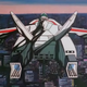 A light gray jet with red markings on its wings soars over a massive city.